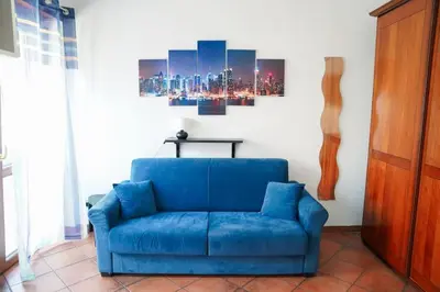 a blue couch in a room with a painting on the wall at Villa Bonelli Loft in Rome
