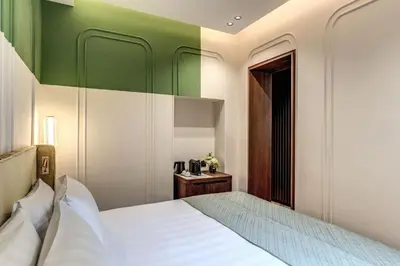 a bedroom with a bed and a green wall at THE STEPS Hotel - by Eitch Collection in Rome