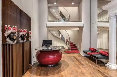 a lobby with a red table and stairs at THE STEPS Hotel - by Eitch Collection in Rome