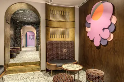 a room with a hallway with a table and stools at THE STEPS Hotel - by Eitch Collection in Rome