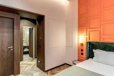 a bedroom with a bed and a door to a hallway at THE STEPS Hotel - by Eitch Collection in Rome