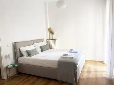 a bedroom with a bed with white walls and wooden floors at Appartamento a due passi da San Pietro, Vaticano in Rome