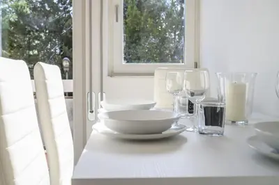 a white table with plates and wine glasses on it at Laura Sweet Home con Piscina in Rome