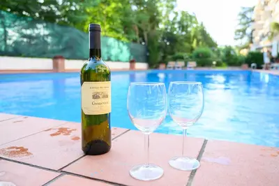 a bottle of wine and two wine glasses on a table at Laura Sweet Home con Piscina in Rome