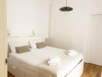 a white bedroom with a large white bed with towels on it at Appartamento a due passi da San Pietro, Vaticano in Rome