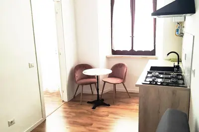 a kitchen with a table and two chairs and a stove at Appartamento a due passi da San Pietro, Vaticano in Rome