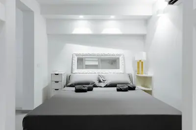 a white bedroom with a large bed and a mirror at Pantheon Experience Suite in Rome