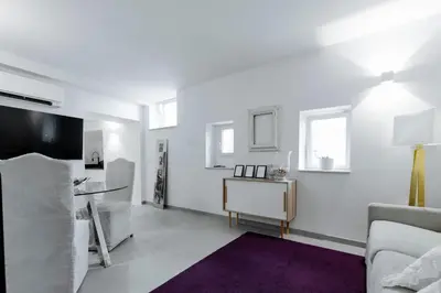 a white living room with a couch and a tv at Pantheon Experience Suite in Rome