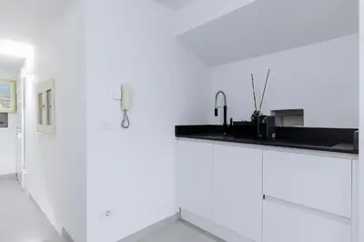 a kitchen with white walls and a black counter at Pantheon Experience Suite in Rome