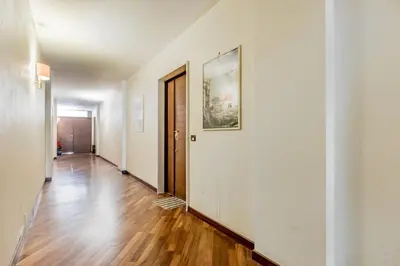 a hallway with white walls and a wooden floor at Luxury apartment front of Cavalieri Hilton Hotel in Rome
