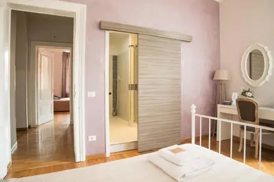 a bedroom with a sliding door leading to a bathroom at Sesto Suites Central in Rome