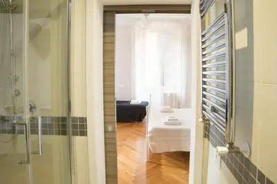 a bathroom with a shower and a room with a bed at Sesto Suites Central in Rome