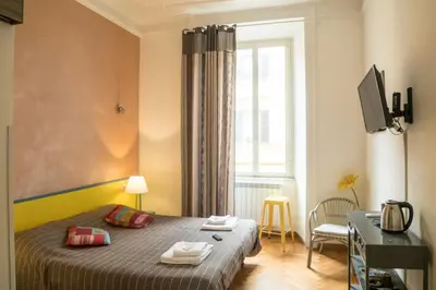 a small bedroom with a bed and a window at Sesto Suites Central in Rome