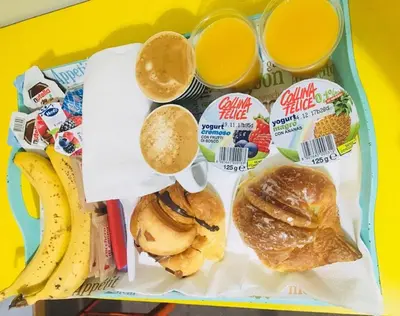 a tray of food with breakfast foods and drinks at Sesto Suites Central in Rome