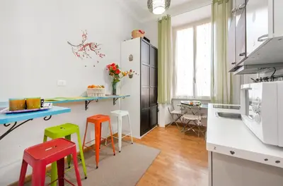 a kitchen with colorful stools in a room at Sesto Suites Central in Rome