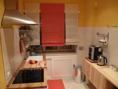 a small kitchen with orange towels on the wall at Arches Inn in Rome
