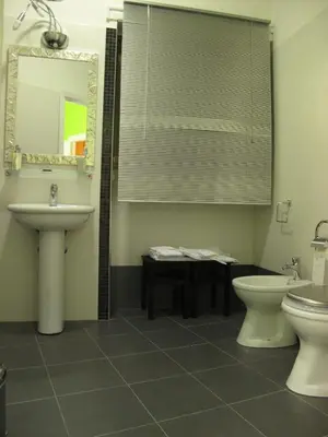 a bathroom with a sink and a toilet and a mirror at Arches Inn in Rome