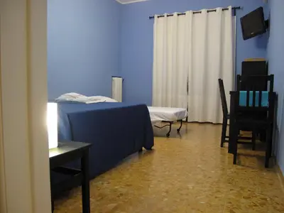 a blue room with a bed and a table and chairs at Arches Inn in Rome