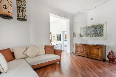 a living room with a white couch and wooden floors at Relais Quinto Piano in Rome