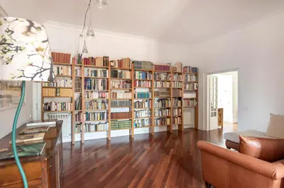 a living room with a large library of books at Relais Quinto Piano in Rome