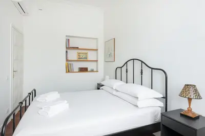 a white bedroom with a bed and a lamp at Relais Quinto Piano in Rome