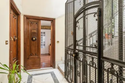 an iron gate in a hallway with a door at Relais Quinto Piano in Rome