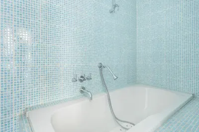 a blue tiled bathroom with a tub and a shower at Relais Quinto Piano in Rome