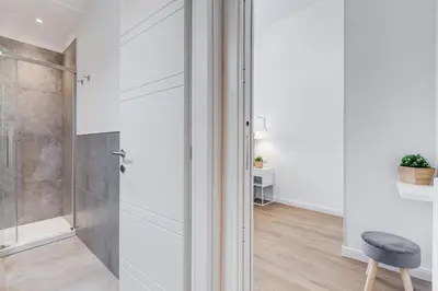 a bathroom with a shower and a stool at Colonna Luxury Apartment in Rome