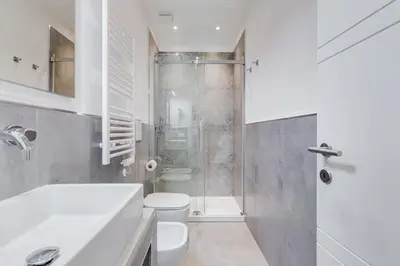 a white bathroom with a shower and a toilet at Colonna Luxury Apartment in Rome