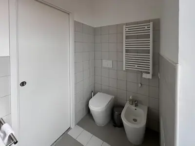 a white bathroom with a toilet and a bidet at Garbatella House in Rome