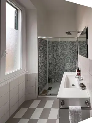 a white bathroom with a sink and a shower at Garbatella House in Rome