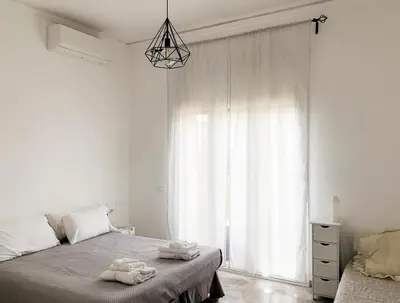 a white bedroom with a bed and a window at Garbatella House in Rome
