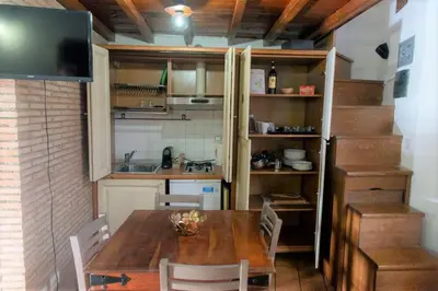 a kitchen with a wooden table with chairs and a television at Monti Wood Loft in Rome
