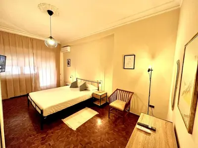 a bedroom with a bed and a chair and a table at Luxurious flat close to the Vatican/metro in Rome
