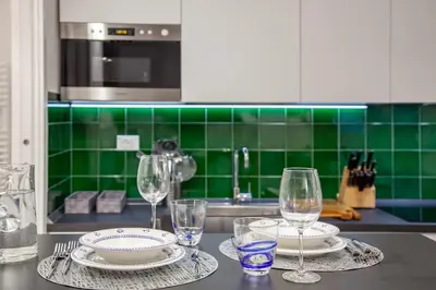 a kitchen with two plates and wine glasses on a counter at Casa Annamaria al Pantheon in Rome