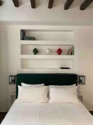 a bed with a green headboard and white pillows at Casa Annamaria al Pantheon in Rome