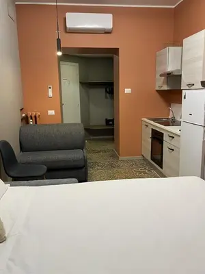 a living room with a couch and a kitchen at Vatican museum guest house in Rome