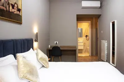 a hotel room with a large bed and a desk at Vatican museum guest house in Rome