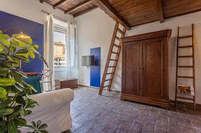 a living room with a white couch and a ladder at Demetra - Little Loft a Trastevere in Rome
