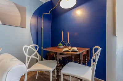a dining room with blue walls and a table and chairs at Demetra - Little Loft a Trastevere in Rome