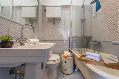a bathroom with a sink and a toilet and a tub at Demetra - Little Loft a Trastevere in Rome