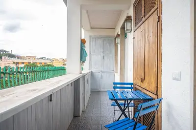 two blue chairs sitting on the balcony of a house at Families apartment in Rome