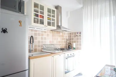 a kitchen with white cabinets and a white refrigerator at Families apartment in Rome