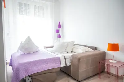 a bedroom with a bed and a chair and a window at Families apartment in Rome