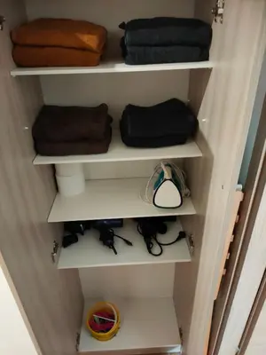 a closet filled with white shelves with towels at THERESA APARTMENT in Rome
