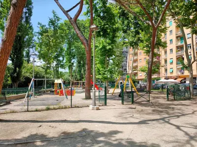 a playground in a park with trees and swings at THERESA APARTMENT in Rome