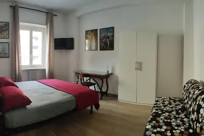a bedroom with a bed and a table and a desk at THERESA APARTMENT in Rome