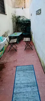 a patio with two chairs and a table and a rug at La Casa di Cinzia in Rome