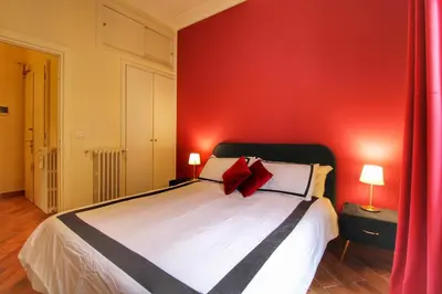 a bedroom with a bed with a red wall at Charming Vatican LargeApt by YH in Rome