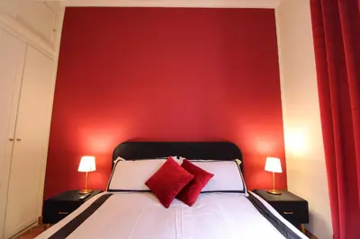 a bedroom with a red wall and a bed with red pillows at Charming Vatican LargeApt by YH in Rome